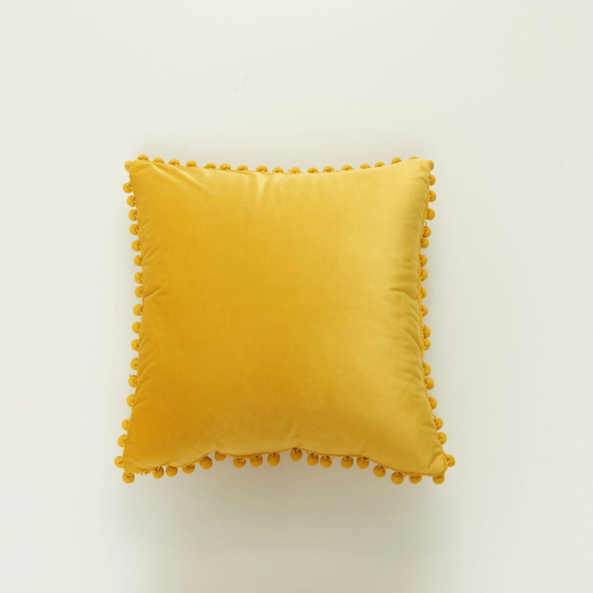 Coussin décoratif en velours à pompons