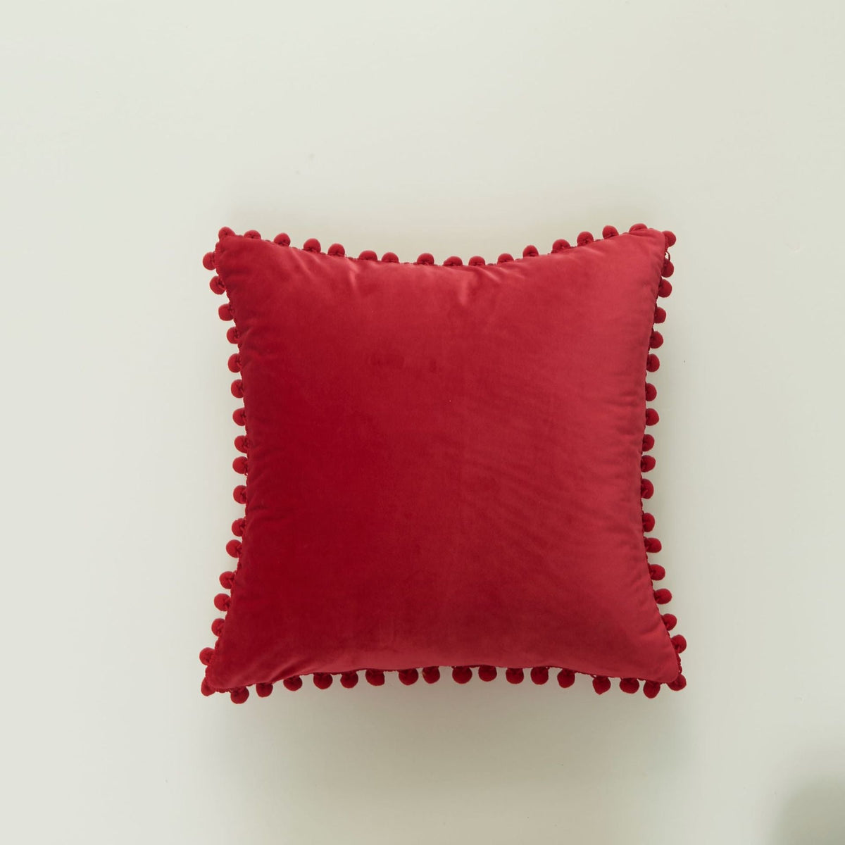 Coussin décoratif en velours à pompons