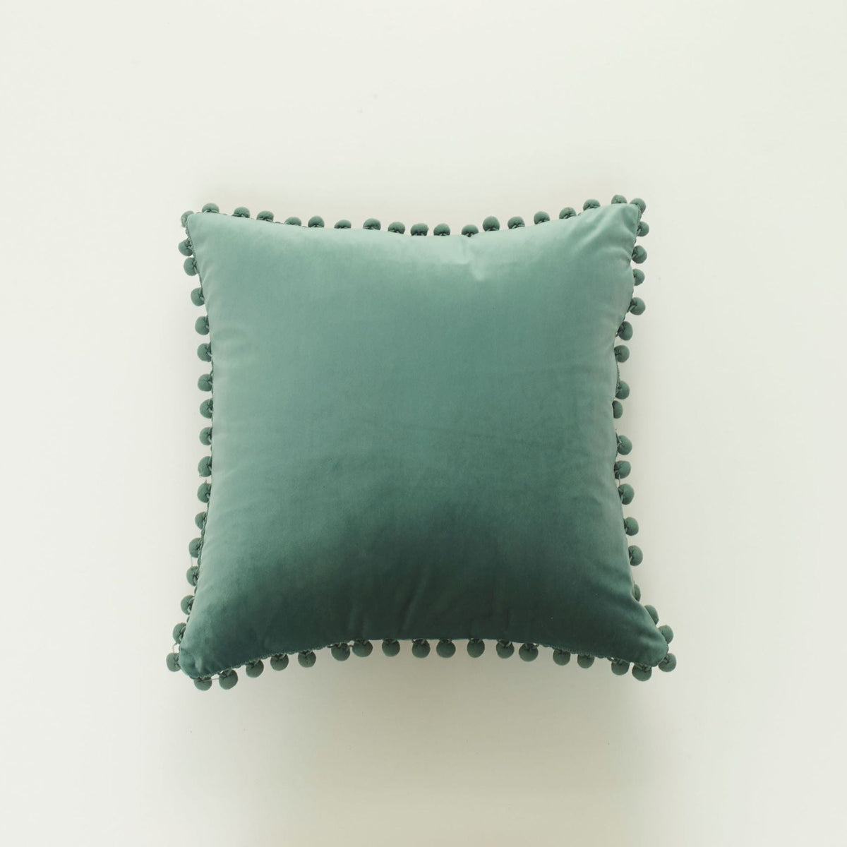 Coussin décoratif en velours à pompons