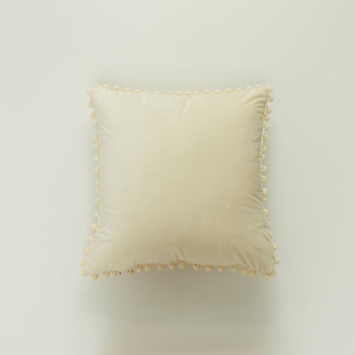 Coussin décoratif en velours à pompons
