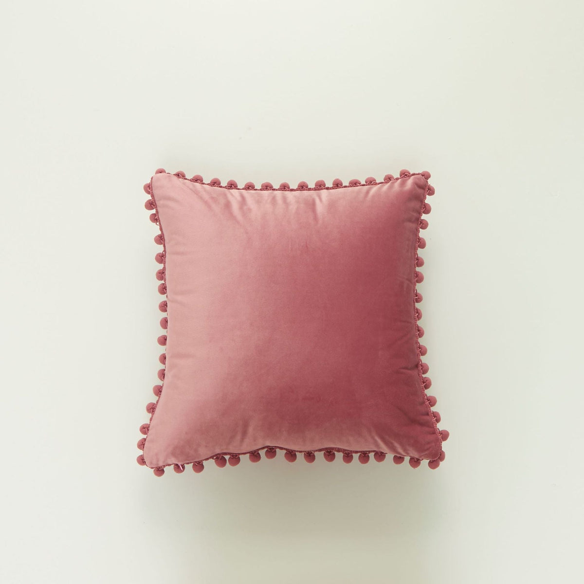 Coussin décoratif en velours à pompons