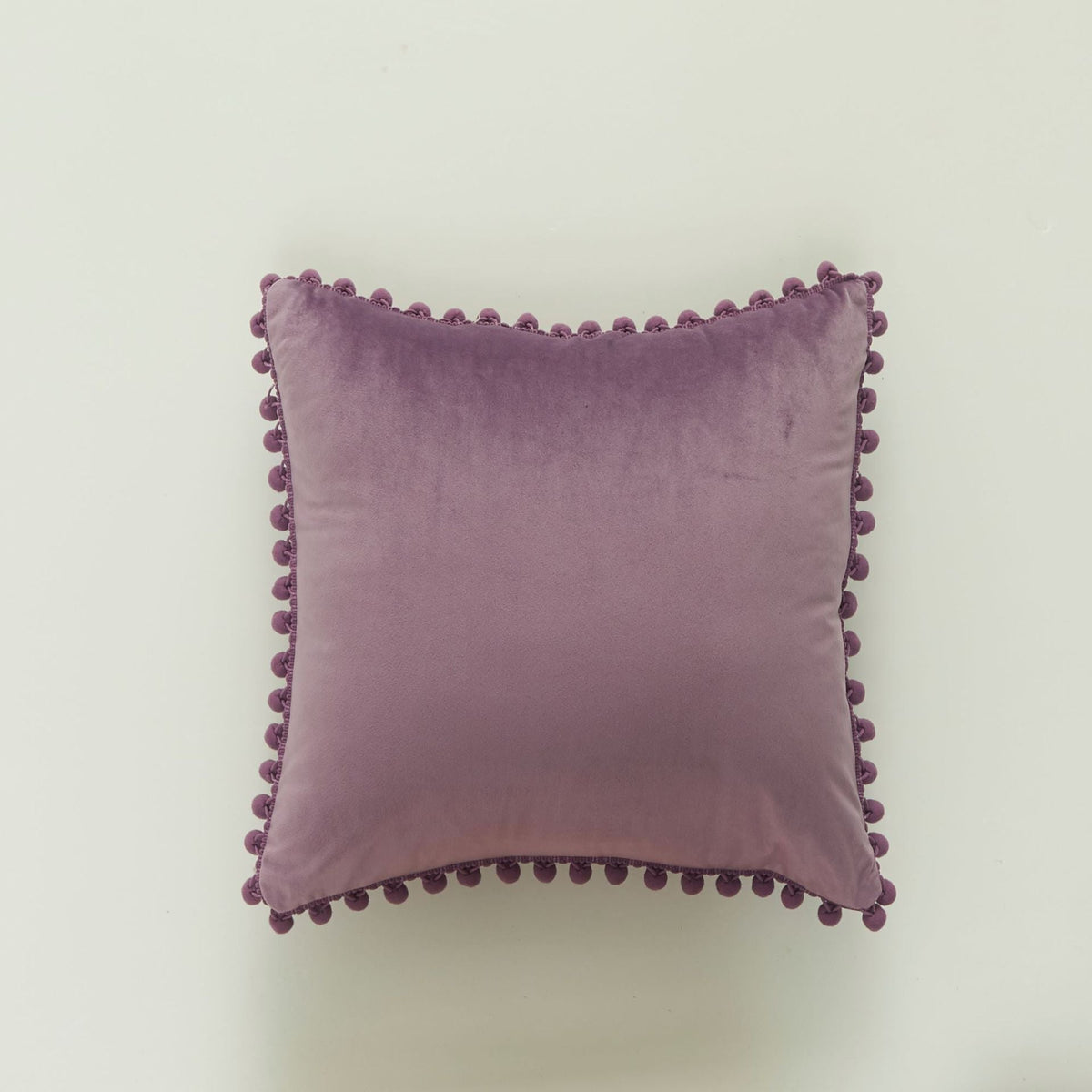 Coussin décoratif en velours à pompons