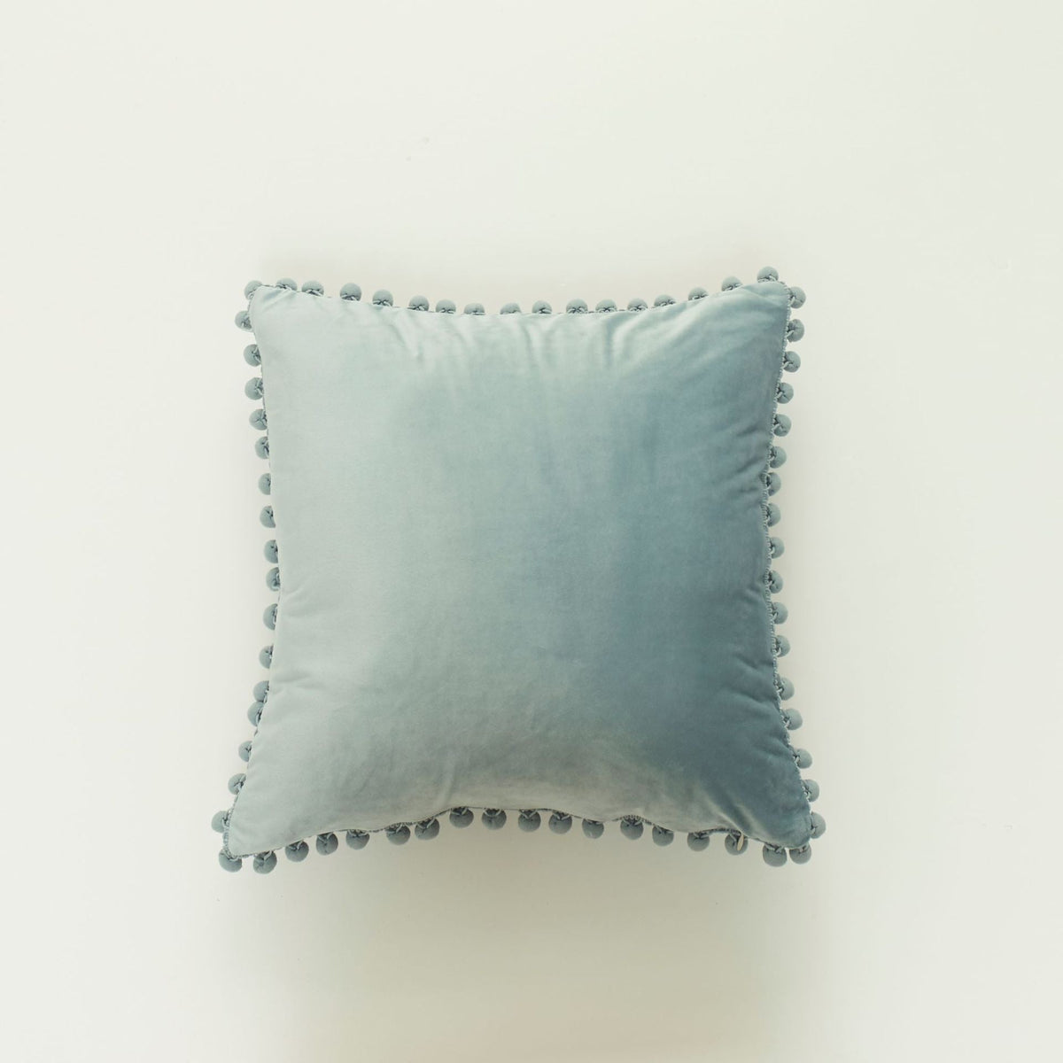 Coussin décoratif en velours à pompons