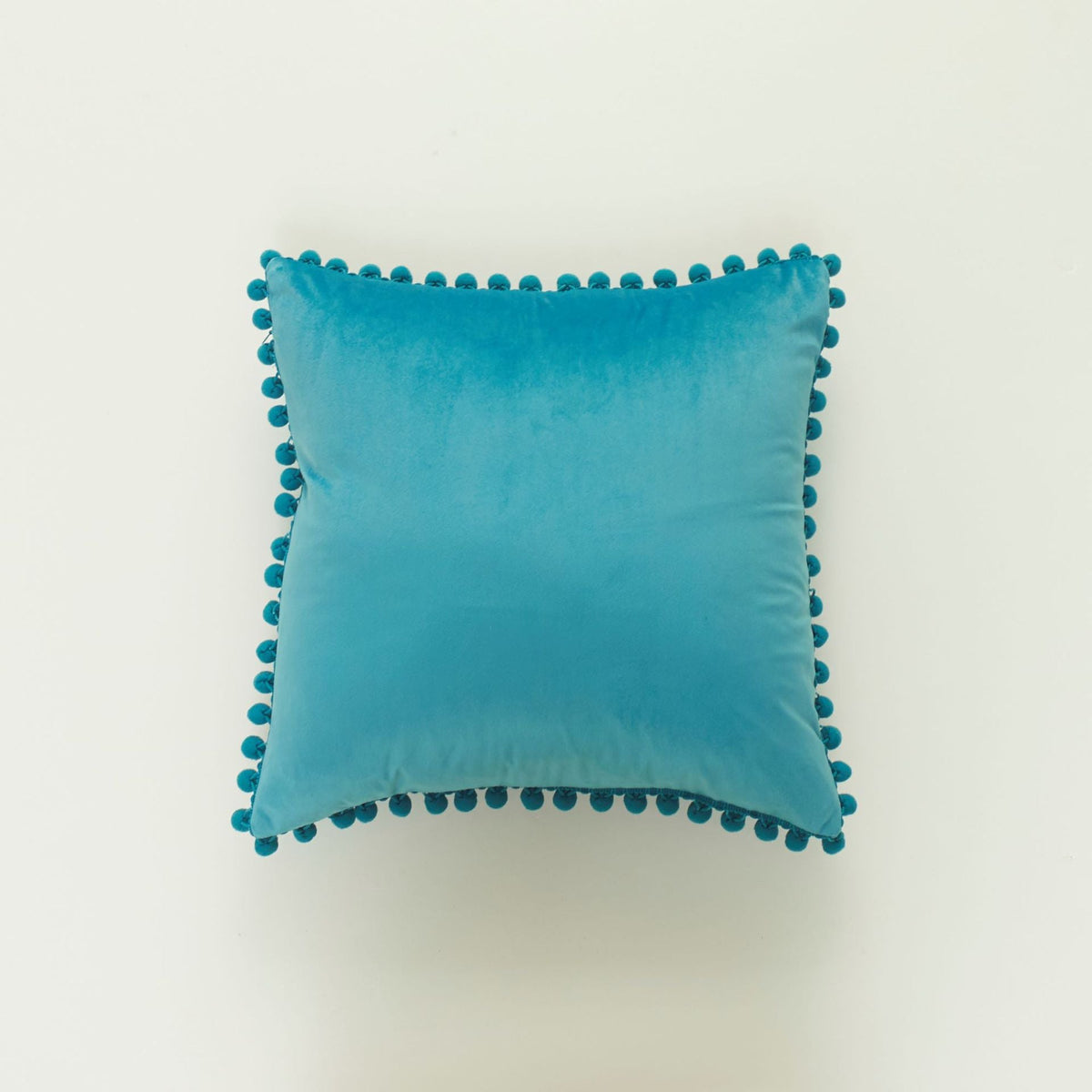 Coussin décoratif en velours à pompons